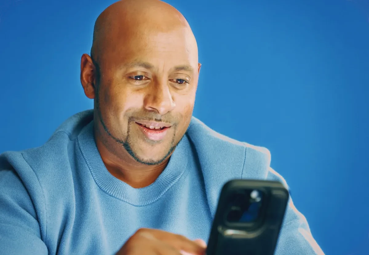 A man smiling at his phone while messaging LawConnect